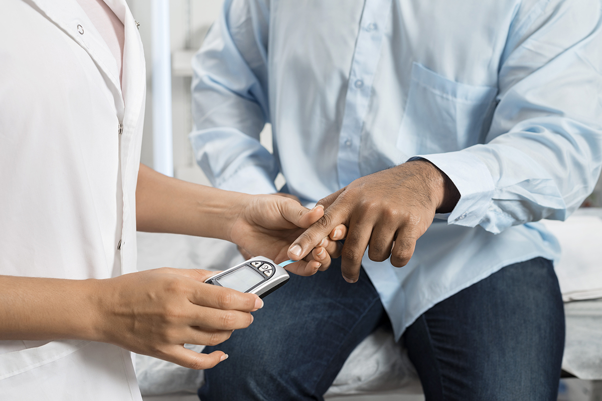 A nurse taking a patient's blood sugar using a glucose machine depicts the diabetes treatment offered by Maumee Integrated Health.